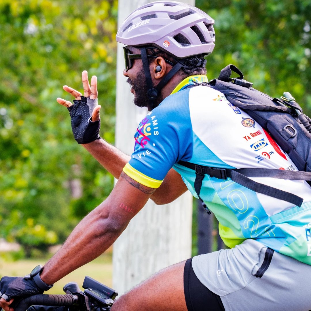 Temitayo on the bike, mid-ride, throwing a peace sign